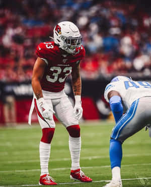 身穿紅色紅雀隊球衣的美式足球員在比賽期間站在球場上。 — NFL 美式足球 壁紙