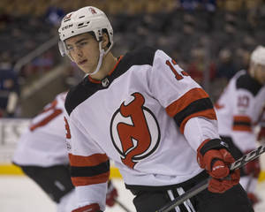 比賽中在冰上穿著紐澤西惡魔隊制服的曲棍球運動員。 — 高解析度 壁紙