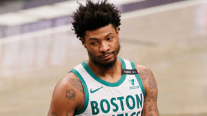波士頓塞爾提克籃球運動員帶有刺青，在球場上看起來很專注。 — 馬庫斯·史馬特 壁紙