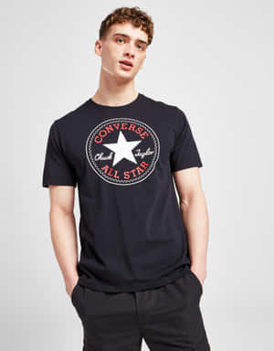 年輕男子在攝影棚內穿著黑色Converse Chuck Taylor All Star T恤。 — Converse 壁紙