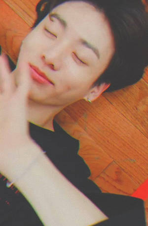 年輕男子在木地板上平靜地睡覺，手靠近臉部。 — Bts 壁紙