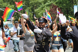 警察在Pride遊行中揮舞彩虹旗，微笑的人群。 — 慶祝 壁紙