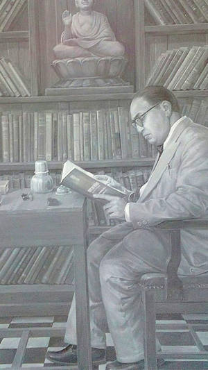 戴眼鏡男子在寧靜圖書館閱讀書籍，有佛像 — 濕婆高清壁紙