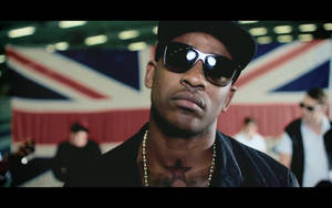 男子在英國國旗前戴著太陽眼鏡和帽子，有星星刺青。 — Skepta 壁紙