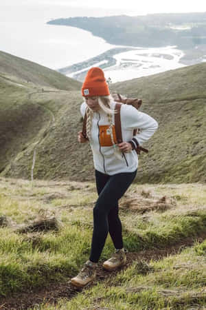 女子在草地山坡上健行，欣賞海岸景色 — 雪山 壁紙
