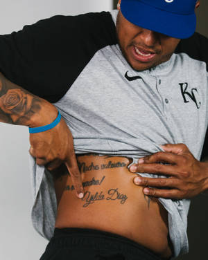 男子指向側身寫有 Madre volviera Yolita Diaz 的刺青 — 運動 壁紙