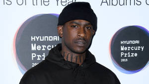 男子在Hyundai Mercury Prize活動中戴黑色毛帽和連帽上衣。 — Skepta 壁紙