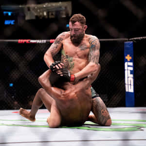 兩名男性MMA拳手在比賽期間於UFC八角籠中纏鬥。 — 運動 壁紙