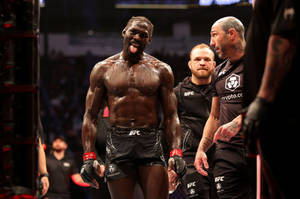 UFC拳手在八角籠中伸出舌頭慶祝勝利。 — 終極格鬥冠軍賽 壁紙