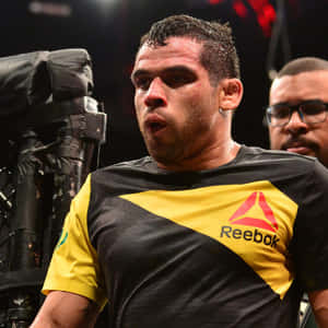 一名專注的MMA戰士在比賽中穿著黑色和黃色的Reebok襯衫。 — 終極格鬥冠軍賽 壁紙