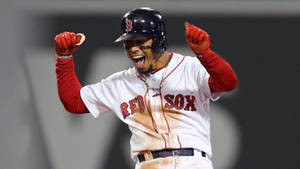 身穿紅襪隊服的棒球選手在夜間高舉拳頭慶祝勝利。 — 慶祝 壁紙