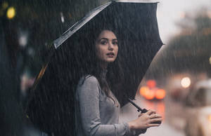 女子在夜晚城市街道的大雨中撐著黑色雨傘。 — 凋零風暴 壁紙