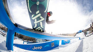 滑雪板選手在冬季運動賽事中磨擦藍色欄杆。 — X Games 壁紙