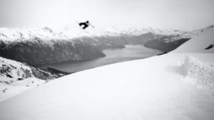 滑雪運動員在黑白相間的雪山和峽灣上空。 — 雪人 壁紙