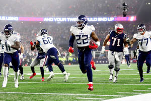 NFL美式足球運動員在夜間比賽中在燈光球場上行動。