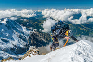 登山者在雲海上攀登積雪的山脊。 — 山景 壁紙