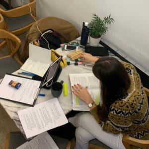 學生在堆滿書籍、咖啡和零食的凌亂桌上學習 — 讀書 壁紙