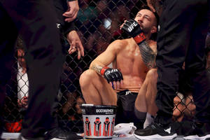筋疲力竭的MMA拳手在八角籠內比賽後飲水。 — 終極格鬥冠軍賽 壁紙