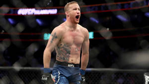 UFC鬥士在八角籠中慶祝勝利，刺青清晰可見。 — 終極格鬥冠軍賽 壁紙