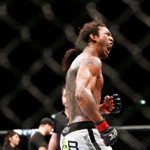 MMA鬥士在UFC八角籠中，以刺青背部和紅色手套慶祝勝利。 — 終極格鬥冠軍賽 壁紙
