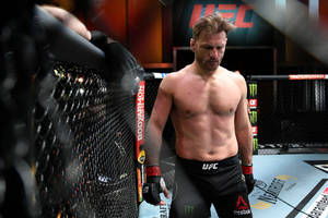 UFC拳手在比賽後筋疲力盡地站在八角籠內 — 運動 壁紙