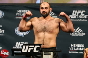 UFC拳手在稱重活動中在磅秤上屈起雙臂。 — 極限運動 壁紙