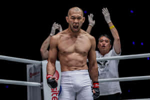 拳擊手在台上與教練高舉雙臂慶祝勝利。 — 運動 壁紙