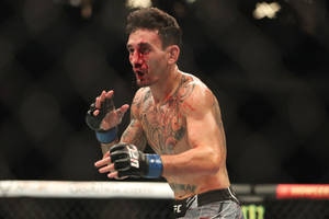 一名滿臉鮮血、帶有刺青的勝利MMA拳手在八角籠內慶祝。 — 運動 壁紙