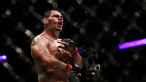 一名渾身是血的勝利MMA拳手在八角籠內慶祝。 — 終極格鬥冠軍賽 壁紙