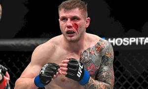 UFC拳手，滿臉鮮血，手臂有刺青，在八角籠內 — 運動 壁紙