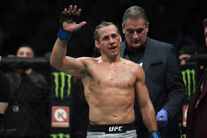 一名滿臉鮮血的勝利MMA拳手在UFC八角籠內向人群揮手。 — 終極格鬥冠軍賽 壁紙