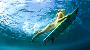 衝浪者在清澈的藍色海洋中拿著衝浪板在水下游泳。 — 衝浪 壁紙
