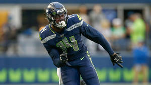 西雅圖海鷹隊美式足球員在比賽中於球場上奔跑 — Dk Metcalf 壁紙