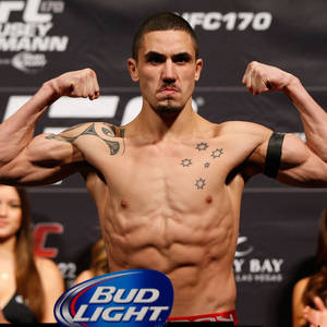 UFC拳手在稱重活動中展示肌肉，Bud Light標誌可見。 — 運動 壁紙
