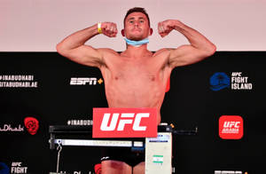 UFC拳手在稱重活動中於磅秤上展示肌肉 — 運動 壁紙
