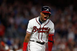 身穿Braves球衣的棒球選手在夜間比賽慶祝勝利。 — 小羅納德·阿庫尼亞 壁紙