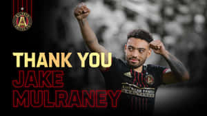 足球運動員舉起拳頭慶祝，文字感謝Jake Mulraney。 — 運動 壁紙