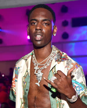 男子在色彩繽紛的夜生活活動中佩戴閃亮珠寶。 — Young Dolph 壁紙
