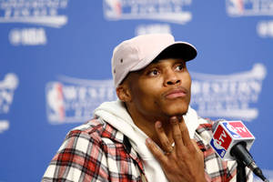 NBA記者會上，籃球運動員手托下巴。 — 羅素·衛斯特布魯克 壁紙