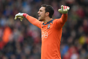 身穿橙色球衣的足球守門員在比賽中舉起雙臂大喊。 — 運動 壁紙
