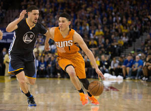 鳳凰城太陽隊球員在NBA比賽中運球越過金州勇士隊防守球員。 — Devin Booker 壁紙
