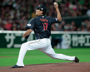 夜間在燈光照亮的球場上投球的棒球投手。 — 混沌武士 壁紙