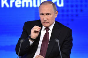 西裝男子在記者會上發言，背景為Kremlin.ru。 — 俄羅斯 壁紙