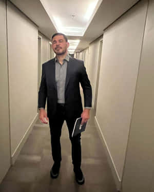 穿西裝男子在飯店走廊拿著平板電腦 — 運動 壁紙