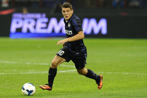 足球運動員在夜間於草地場上在體育場燈光下運球。 — 橘色 壁紙