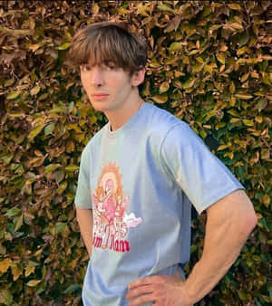 年輕男子身穿藍色T恤站在綠色籬笆旁 — 火鶴 壁紙