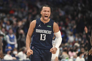 身穿獨行俠球衣的籃球運動員在比賽中張嘴慶祝。 — 運動 壁紙