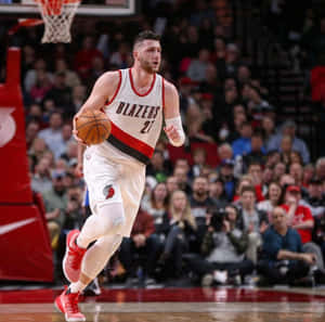 身穿 Blazers 球衣的籃球運動員在比賽中運球，觀眾在場。 — 運動 壁紙