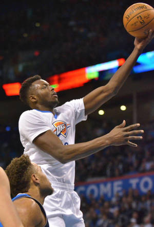 籃球運動員在比賽中投籃，防守球員在附近。 — NBA 壁紙