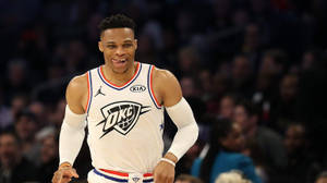 身穿白色OKC球衣的籃球運動員在比賽中微笑。 — 羅素·衛斯特布魯克 壁紙